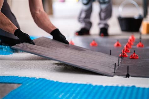 Foto van een professional die een tegelvloer legt met het FixPlus levelling systeem