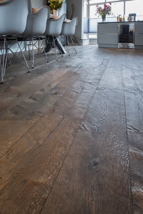 Voorbeeld van een gerookte eikenhouten vloer met een gemêleerd effect van lichte en donkere planken.