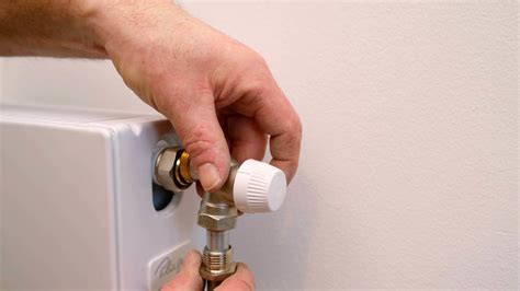 Afbeelding van een installateur die een radiator aansluit