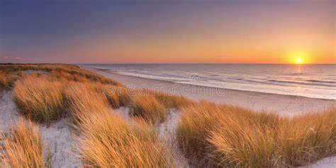 Afbeelding: panoramisch strand en duinen bij zonsondergang