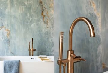 Afbeelding van een badkamer met blauw marmer wand en koperen kranen