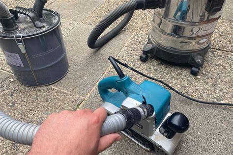 Illustratie van een schuurmachine met stofafzuiging en een stofbox