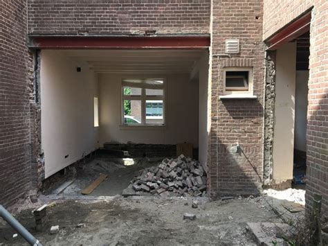 Foto: activiteit tijdens de verbouwing in Workum, met bouwmateriaal en arbeiders