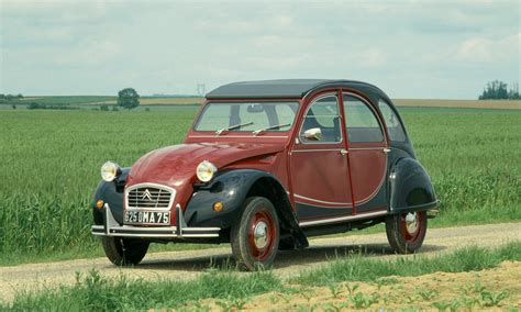 De Citroën 2CV met nieuw dak, rijdend door het Toscaanse landschap met bloeiende irissen.