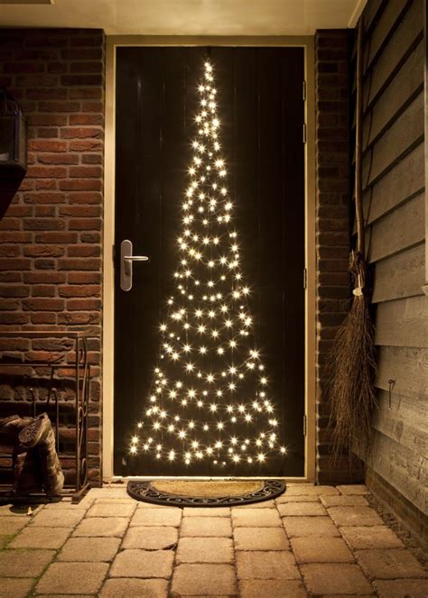 Men ziet een composite afbeelding van buitenversieringen met kerstlampen, guirlandes en een Fairybell deurkerstboom