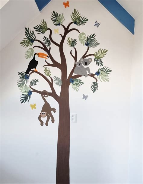 Handgemaakte behangboom met dierenfiguren voor een kinderkamer