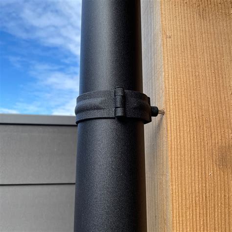 Voorbeeld van een antraciet aluminium regenpijp met bijpassende beugels aan een gevel