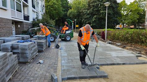 Foto van een team stratenmakers van Verschuren Groen aan het werk aan een oprit.