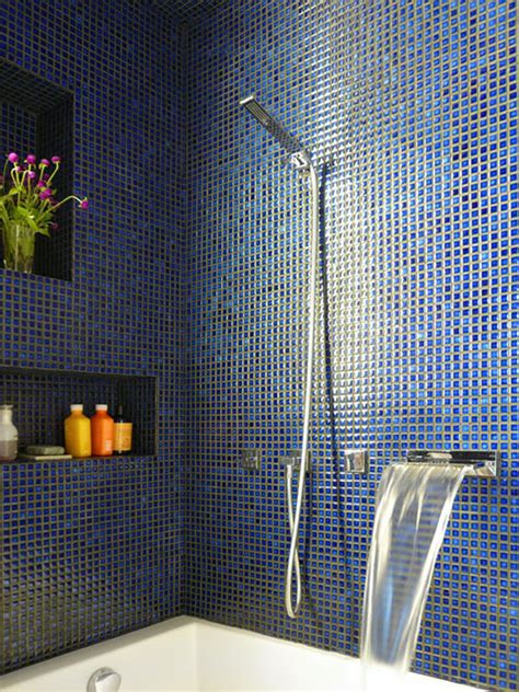 Een luxe badkamer met blauwe mozaïek tegels op de douchewand en subtiele gouden accenten.