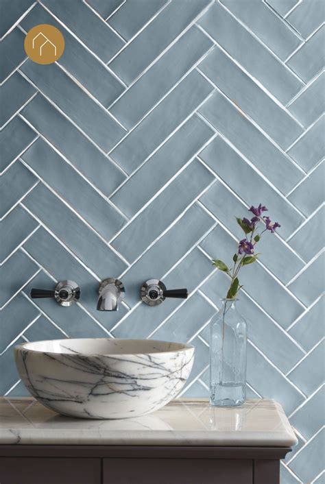 Een badkamer met blauwe visgraat tegels op de wand, gecombineerd met houten elementen.