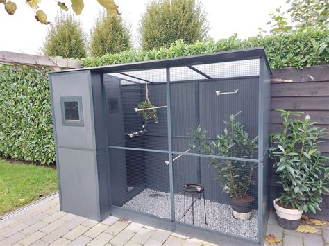 Een stijlvolle, aluminium volière met dak, tentoongesteld in een tuin.