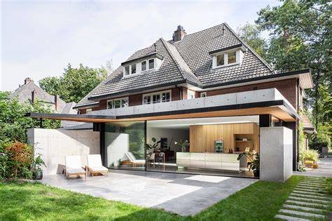 Afbeelding van een moderne renovatie van een jaren 30 woning met bronzen kozijnen en pergola