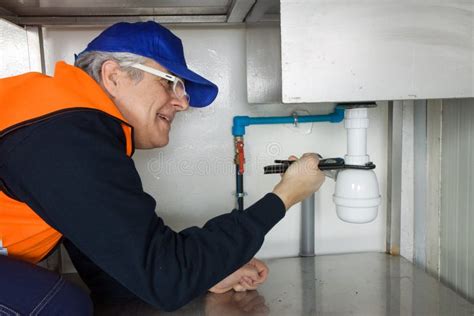 Een professionele loodgieter aan het werk met gereedschap