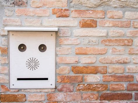 Illustratie van een intercom met camera bij een voordeur.