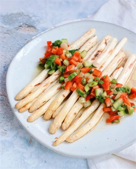 Paarse asperges in kapsel van lichtgroene binnenkant en donkergroene buitenkant, zoals ze bij een groentewinkel liggen. De kleurcrème onthult hun karakter.