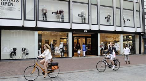 Diverse producten uit de webwinkel van Kees de Waal, waaronder schapentextiel, mokken en decoratieve items.