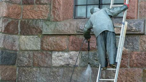 Een professioneel team dat een gevel reinigt met gespecialiseerde apparatuur