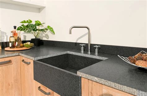 Overzicht van verschillende toepassingen van betonstuc in de keuken: aanrechtblad, spatwand, vloer en keukenkastjes.