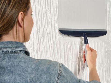 Foto van een muur die wordt gladgestreken met de Alabastine Muurglad Strijker.