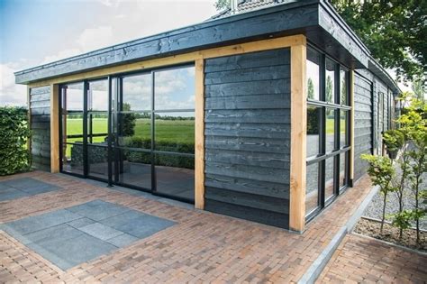 Een modern prefab tuinhuis met veranda, met een strak lessenaarsdak en glazen pui.