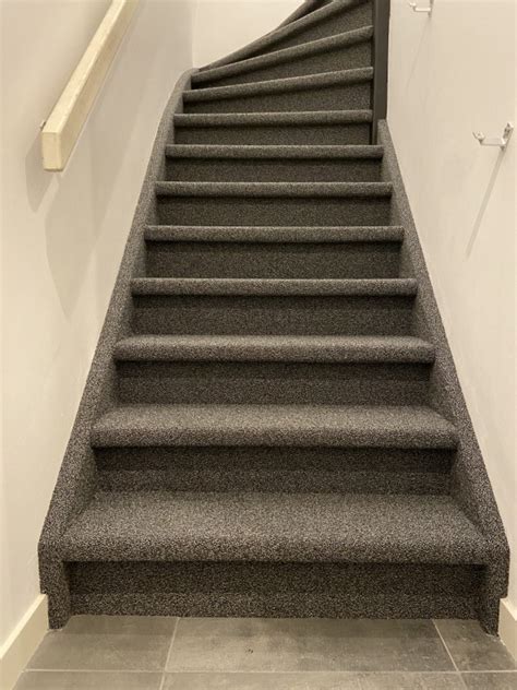 Foto van een trap bekleed met zacht, warm tapijt
