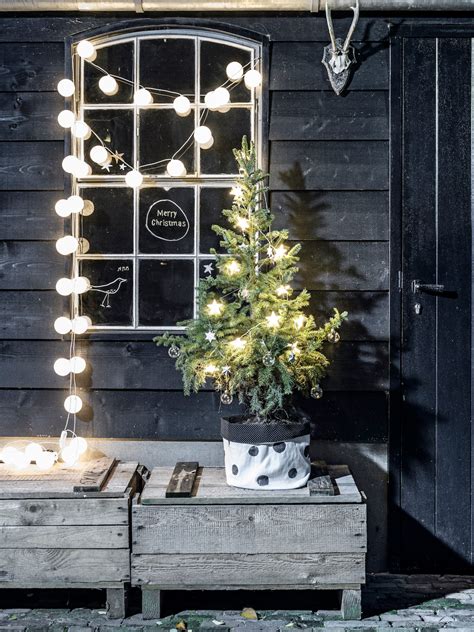 Illustratie van kerstverlichting langs tuinhek en bomen
