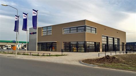 Goudkleurige Colorcoat Prisma Ephyra gevel voorzichtige installatie met SAB-Pyramid profielen langs een kustlandschap
