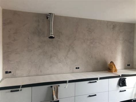 close-up van het aanbrengen van beton ciré op een keukenwerkblad met een spaan