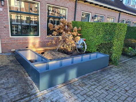 Een groep planten in een stijlvolle plantenbak die verwarmingsbuizen aan het oog onttrekt.