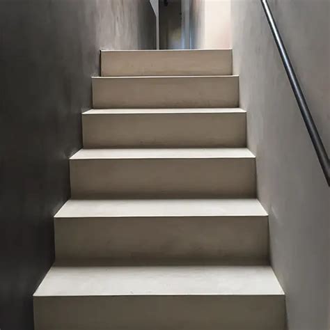 Afbeeldingen van verschillende afwerkingen op hout: microcement op een trap, beton ciré op een tafelblad.