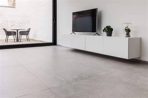 Een moderne woonkamer met een betonlook tegelvloer