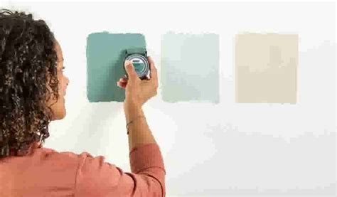 iemand die een muursticker aanbrengt met een gladstrijkplastic, waarbij luchtbellen worden weg gestreken