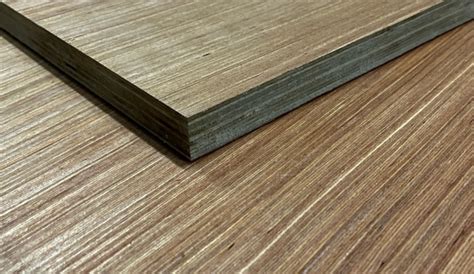 Detailfoto van een losgelaten fineerlaag op een oud meubelstuk