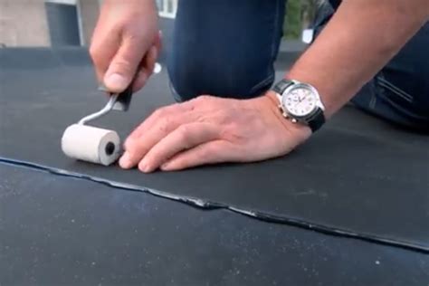 Illustratie van het aanbrengen van lijm op het dakvlak en het aandrukken van de EPDM folie met een roller.