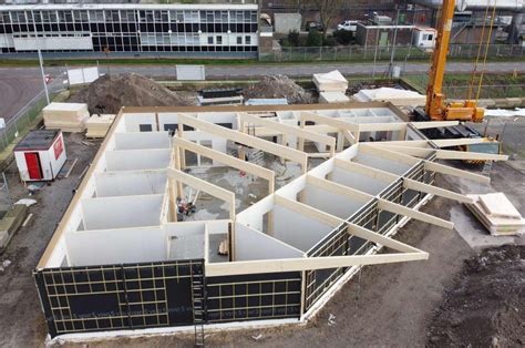 Illustratie van prefab elementen die op een bouwplaats worden samengevoegd.
