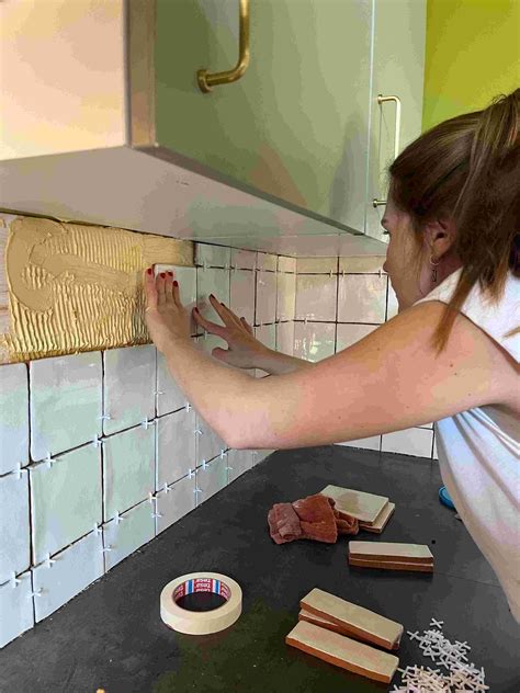 Gedetailleerde afbeelding van het plaatsen van tegels met tegelkruisjes en het aanbrengen van voegmiddel