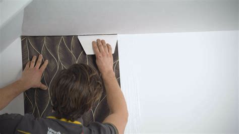 Gedetailleerde voorbereiding van een muur voor behangen, inclusief het verwijderen van oud behang en plamuren.