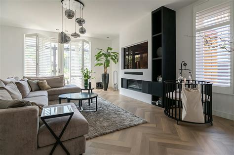 Foto van een moderne woonkamer met grote kunststof kozijnen.