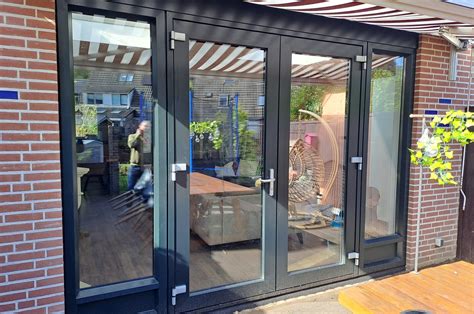 Foto van een gerealiseerde aanbouw met kunststof kozijnen, inclusief openslaande deuren en zijramen