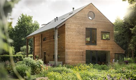 Voorbeeld van een moderne prefab woning met houtskeletbouw, diverse kozijnopties en duurzame gevelbekleding.