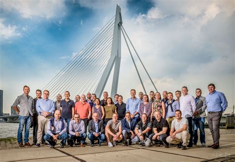 Een grote groep lachende familieleden en vrienden die poseren voor een groepsfoto.