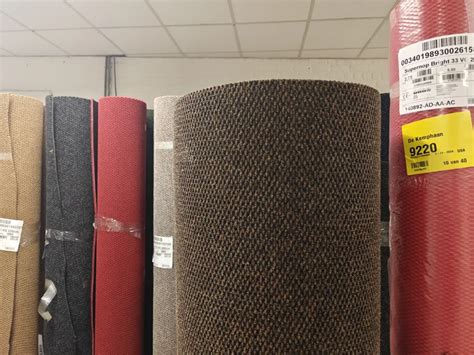 Een stapel met diverse rollen outlet tapijt met prijsaanduidingen