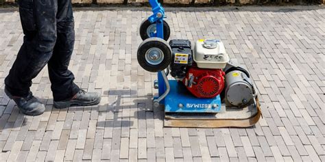 Foto van een trilplaat die klinkers aandrukt op een terras