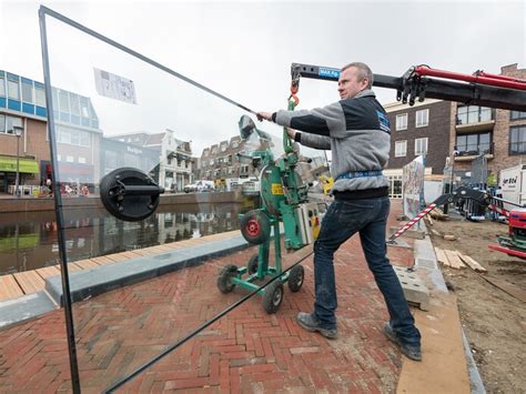 Een professionele glaszetter die een ruit plaatst.