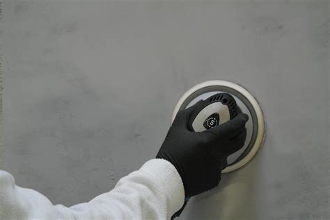 Illustratie van het schuren van Beton Cire met een excentrische schroefmachine.