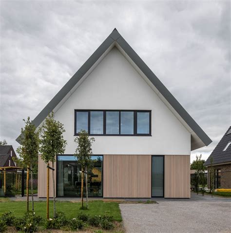 Foto van een woning met gerenoveerde gevel en nieuwe dakranden.