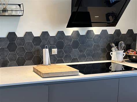 hexagon tegels achter een zwarte spoelbak in witte keuken