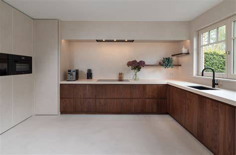 Afbeelding: Donker houten fronten in een moderne keuken met licht werkblad en warme detailverlichting