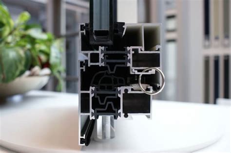 Infographic die de constructie van een modern, thermisch onderbroken aluminium kozijn toont met de isolator tussen de binnen- en buitenschaal en de verschillende luchtkamers.