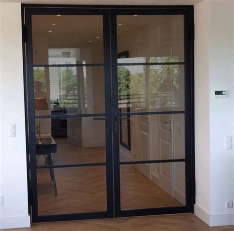 Een moderne stalen binnendeur met rookglas, geplaatst in een interieur.